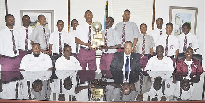 SEATED (l-r) are coach Munroe, coach Sears, Minister Darville, coach McIntosh and coach Higgs. Standing behind holding the trophy are the two MVPs - Sherman Robinson Jr and Frankly Petiun.  