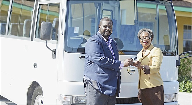 Kenred Dorsett, Minister of the Environment and Housing, presents the keys to a new school bus to Anatol Rodgers School principal Myrtle McPhee and, left, with children during the school’s morning devotion.
Photos: Shawn Hanna/Tribune Staff