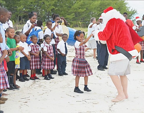 Santa Claus gets a warm welcome from R N Gomez All Age School students in the Berry Islands as he arrives by seaplane to get Christmas celebrations under way. 
