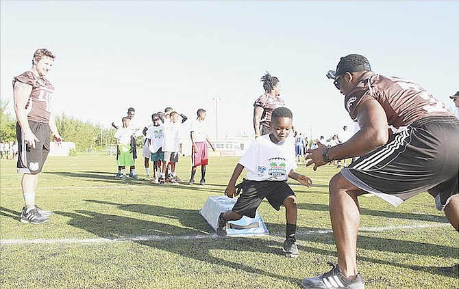 DOZENS of youth take part in various drills by the USA Football staff players during a Youth Football Leadership Clinic at the Roscow Davies Soccer Field yesterday.
                                                                                                                                                                                                                                                                 Photo by Tim Clarke/Tribune Staff