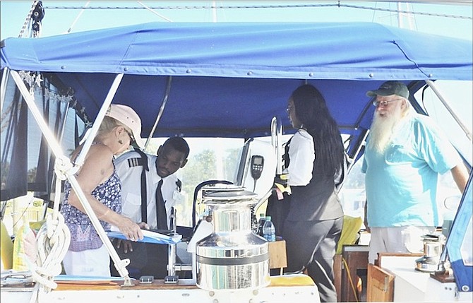 Customs officers and Palm Cay Marina Manager Demaro Demeritte welcome Mike Fish and Martha Garczynski aboard Layla, the first vessel to clear Customs at Palm Cay following its being named an official port of entry.
