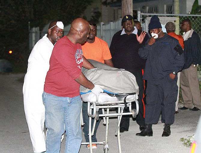 Officers remove the body from a Pinewood home on Tuesday night. Photo: Tim Clarke/Tribune Staff
