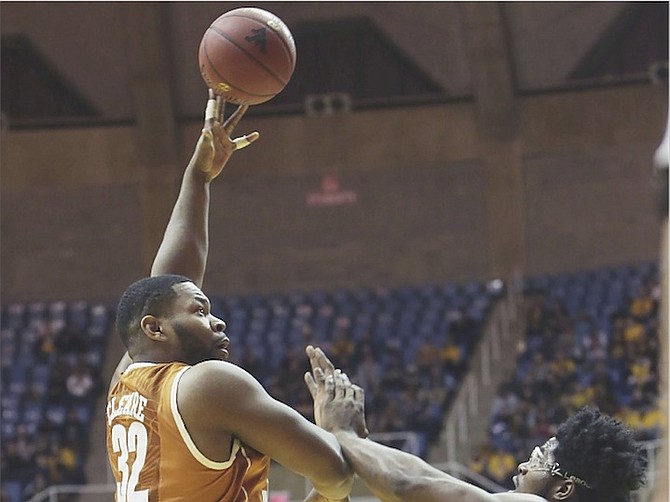 Texas forward Shaquille Cleare (32) takes a shot while being defended by West Virginia forward Devin Williams (41) in the first half of an NCAA college game on Wednesday night. (AP)