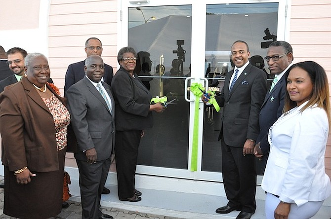Dion Smith, Executive Chairman of the Bahamas Agriculture and Industrial Corporation, cuts the ribbon to open the Grand Bahama Arts and Craft Centre in Freeport, watched by Deputy Prime Minister Philip Davis, Agriculture Minister V Alfred Gray and others on Thursday. Photo: Vandyke Hepburn/BIS