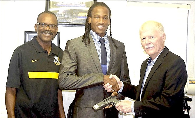 JR McDonald (right) shakes the hand of special guest Jeffery Gibson as they hold the new electric gun. At left is Star Trackers Track Club’s head coach David Charlton.
Photo by George Ratliffe