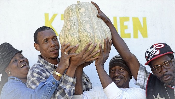 From left, Zelma Bevans, Elijah Culmer, I Rolle and Philander Bevans pictured holding up the giant pumpkin. Photos: Shawn Hanna/Tribune Staff