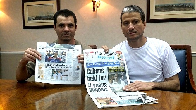 Carlos Pupo and Lazaro Seara view the headlines about their release.