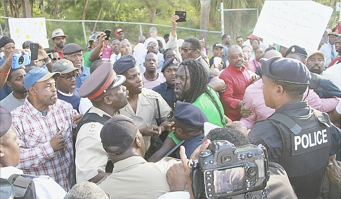 A face-off between protestors and police officers yesterday as the fence shutting off access to Cabbage Beach for vendors was torn down. Photos: Tim Clarke/Tribune Staff