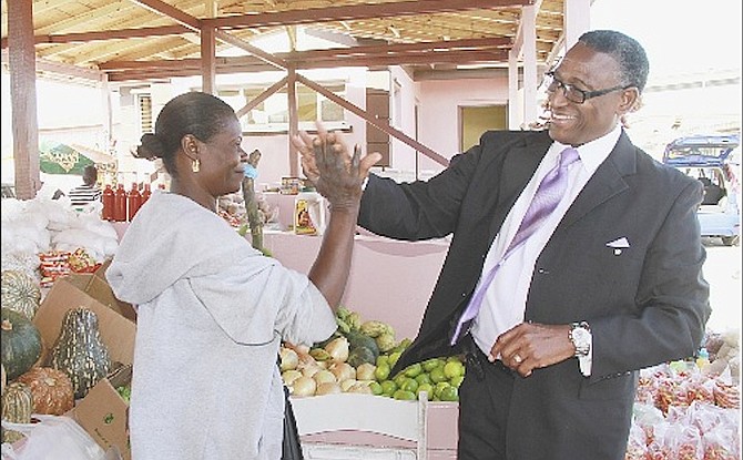 Minister of Agriculture and Marine Resources Alfred Gray greets a vendor at Potter’s Cay Dock yesterday.