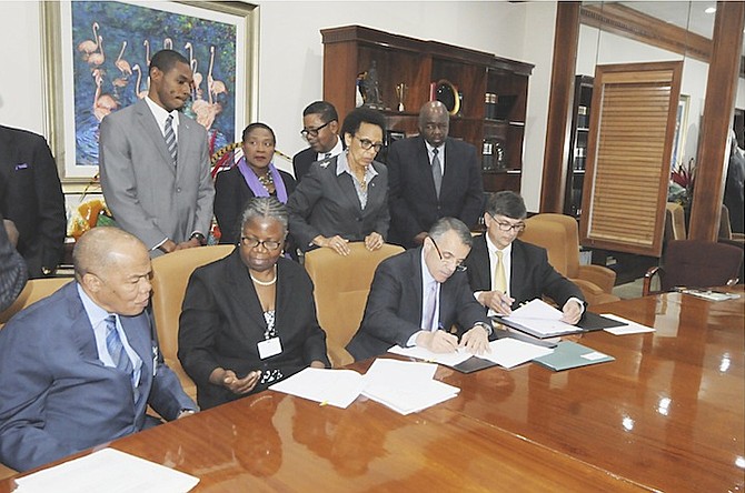 Dr Joshua Hare signs a consultancy services agreement with the Ministry of Health at the Office of the Prime Minister watched by Dr Dean Goldschmidt. Photo: Peter Ramsay/BIS
