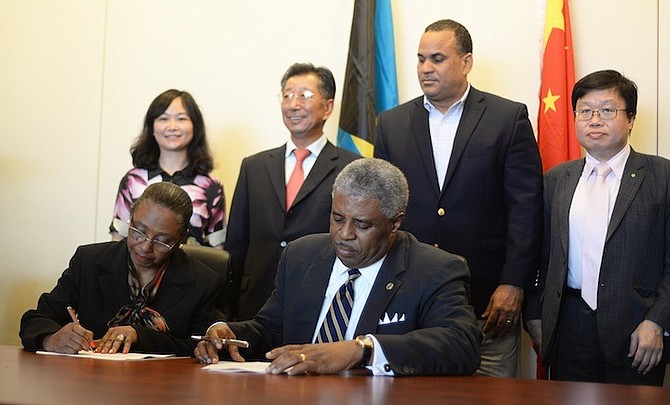 The handing over of the Baha Mar Convention Centre from the China Export Import Bank to the Bahamas Government to host the IDB-IIC agm. Janeen McCartney, Project Coordinator, and Deloitte and Touche (Bahamas) Managing Partner Raymond Winder are pictured signing the agreement. Photo: Shawn Hanna/Tribune staff