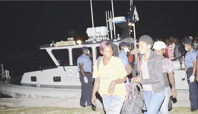 RBDF marines assist migrants as they disembark HMBS P44 upon arrival at the Coral Harbour base. 
Photo: Marine Seaman Stefan McDonald