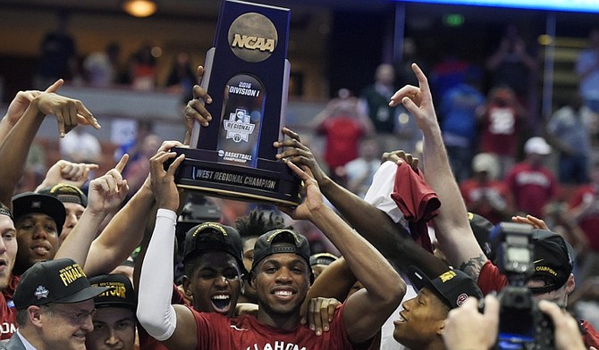 Oklahoma guard Buddy Hield, centre, holds the trophy after their win against Oregon during an NCAA college basketball game in the regional finals of the NCAA Tournament, Saturday in Anaheim, Calif.(AP Photo/Mark J. Terrill)
