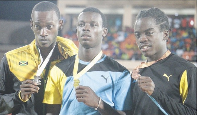 JOB WELL DONE: Kendrick Thompson (centre) and Ken Mullings (far right) share the stage with Jamaica’s Marcus Brown, the silver medallist in the boys’ open octathlon.