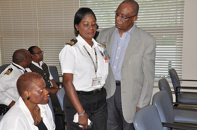 Assistant Comptroller of Customs, Skerick Martin assists a grieving Elsa Neely in Freeport on Friday. Also pictured seated is trained psychologist Dr Pamela Mills. Photo: Vandyke Hepburn/BIS
