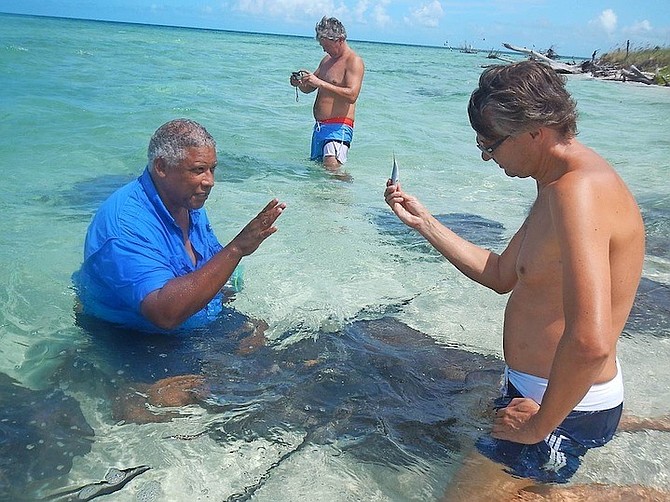 Keith Cooper, left, pictured during one of the tours that he operates to allow people to encounter stingrays.