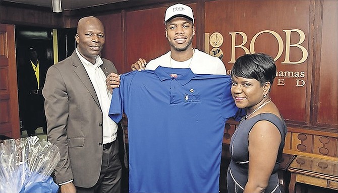 COURTESY CALL – Buddy Hield receives a “Team BOB” cap and T-shirt along with a gift basket from Bank of The Bahamas Limited. Shown (l-r) are Hubert Edwards, chief business development officer at BOB, Buddy Hield and Renee Davis, managing director.