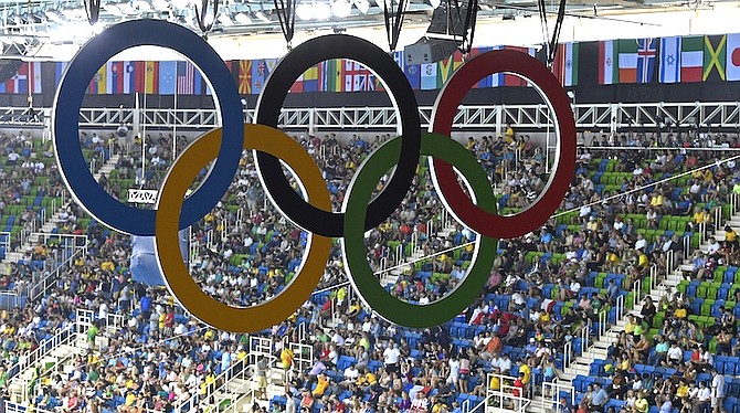 The Olympic rings hang over the spectators of the swimming competitions. (AP)