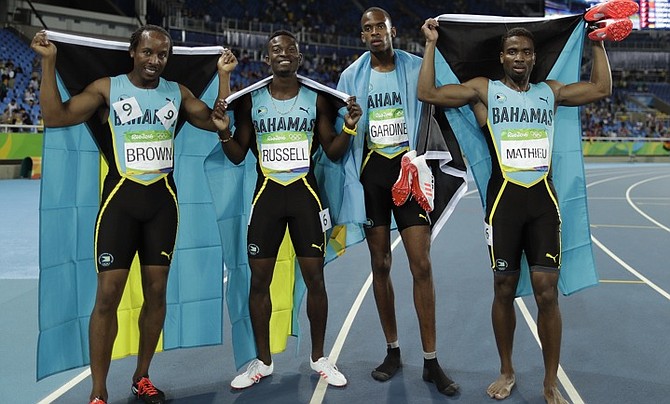 Alonzo Russell, Michael Mathieu, Steven Gardiner and Chris Brown celebrate winning the bronze medal for the Bahamas in the men's 4x400m relay. (AP)