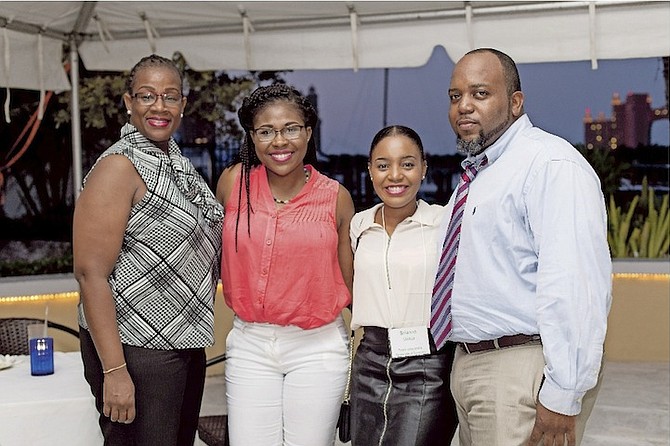 Scholars Erin Johnson (middle left) and Brianna Tinker (middle right) with their parents. 
Photo: Disha Fraser/CayFocus Photography
