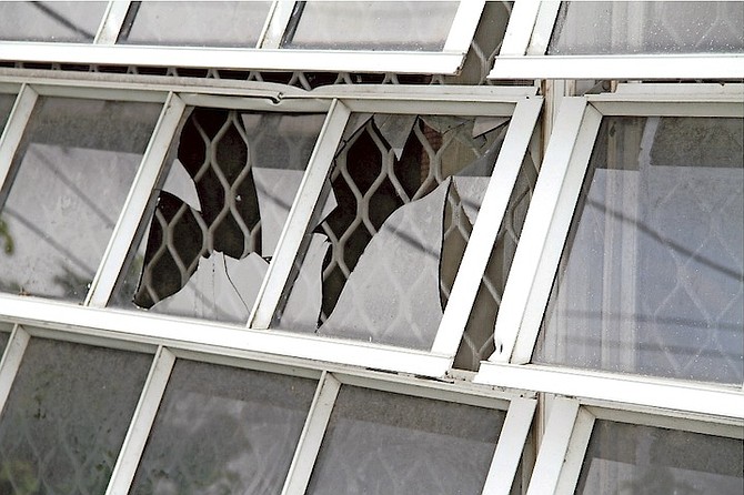 Shattered windows yesterday at the house where John Jamal Pinder Jr was shot dead. Photo: Tim Clarke/Tribune Staff