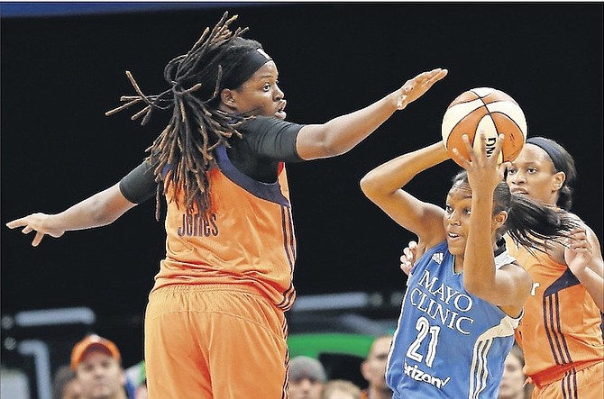 Minnesota Lynx’s Renee Montgomery (21) tries to pass the ball behind Connecticut Sun’s Jonquel Jones, of the Bahamas, during the first half of a WNBA game on Sunday in Minneapolis. 
     (AP Photo/Stacy Bengs)