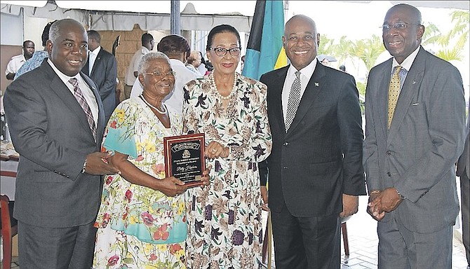Deputy Prime Minister Philip ‘Brave’ Davis helps to present an award to Betty Hepburn for dedicated service to the straw market yesterday, alongside Governor General Dame Marguerite Pindling, Tourism Minister Obie Wilchcombe, and straw market chairman Kevin Simmons. Photo: Tim Clarke/Tribune Staff