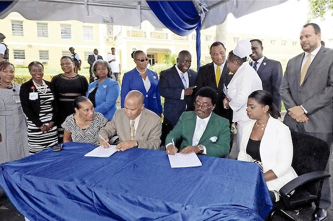 Prime Minister Perry Christie, back, at Wednesday's contract signing, with the contract being signed by, from left, Leslie Isaacs, Herbert Brown, Hubert Fowler and Phillippa Pinder. 
Photo: Peter Ramsay/BIS