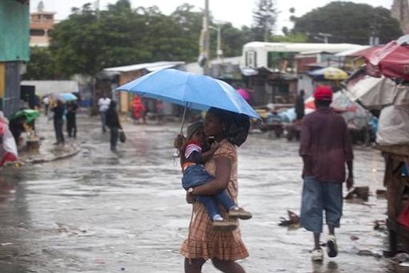 A woman carrying a child walks in the rain triggered by Hurricane Matthew in Port-au-Prince, Haiti, on Tuesday. Photo: Dieu Nalio Chery/AP