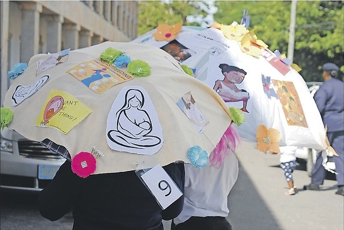 Umbrellas decorated with pro-breastfeeding messages and images.
