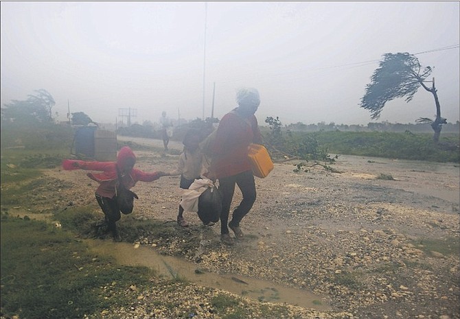 Residents head to a shelter in Leogane, Haiti, yesterday. Matthew slammed into Haiti’s southwestern tip with howling, 145 mph winds, tearing off roofs, uprooting trees and leaving rivers bloated and choked with debris.  Photo: Dieu Nalio Chery/AP