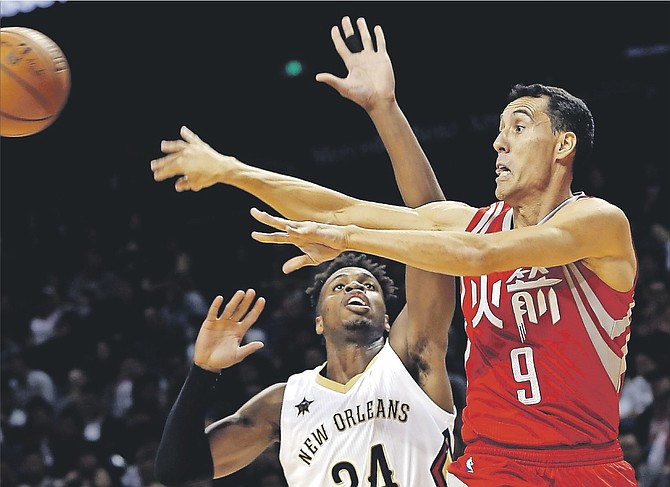 Rockets Pablo Prigioni, right, passes the ball as New Orleans Pelicans Buddy Hield, of the Bahamas, attempts to block during their preseason NBA game in Shanghai, China, on Sunday. (AP Photo)
