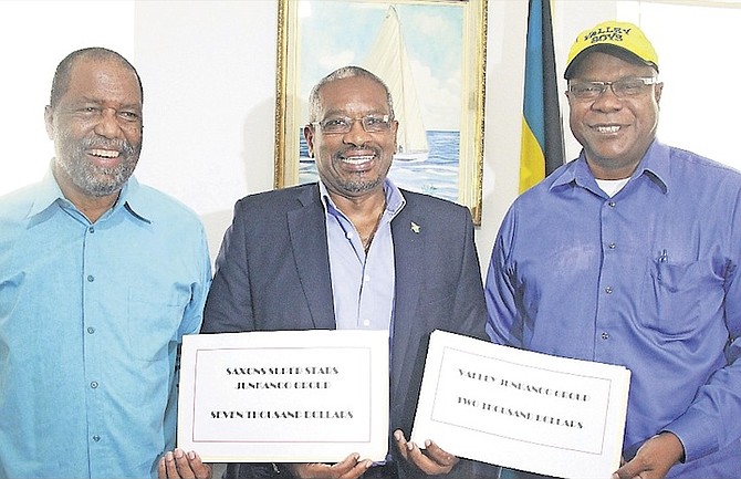 FNM Leader Dr Hubert Minnis donating money yesterday to the Shells Saxons Super Stars, represented by leader Percy Vola Francis, left, and Valley Junkanoo Group chairman Brain Adderley.