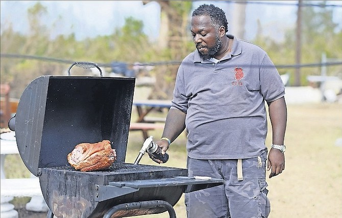Simeon Hall Jr using his outside grill in the South Beach community yesterday. Photo: Shawn Hanna/Tribune Staff