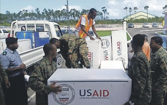 Royal Bahamas Defence Force marines loading tarpaulin on the back of trucks for distribution to residents in New Providence, who suffered roof damage during the passage of Hurricane Matthew last week. Photo: NEMA
