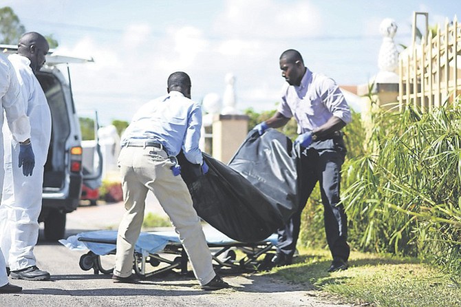 The body of the man is removed from the scene in Pinewood Gardens. Photo: Shawn Hanna
