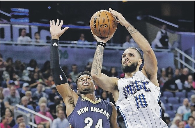 Orlando Magic’s Evan Fournier (10) takes a shot in front of New Orleans Pelicans’ Buddy Hield (24) during Thursday’s preseason game. Orlando won 114-111 in overtime. (AP)