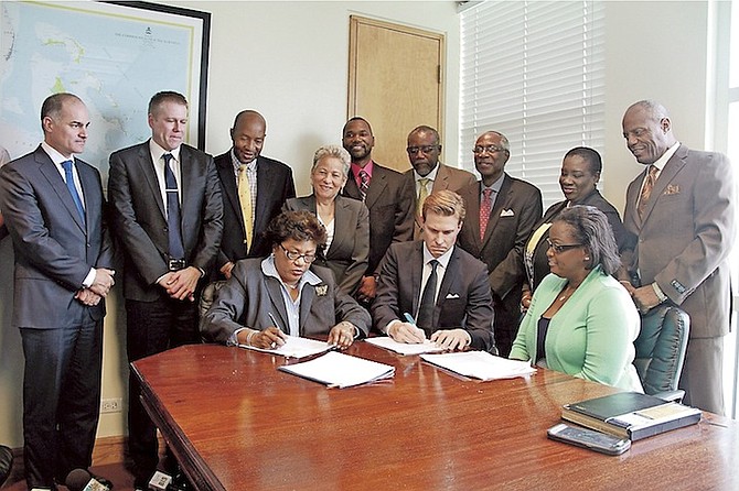 Permanent secretary Lorraine Ambrister and Vaisala regional director Aleksis Kajava sign contracts for new doppler radars at the Ministry of Transport. Photo: Tim Clarke/Tribune Staff