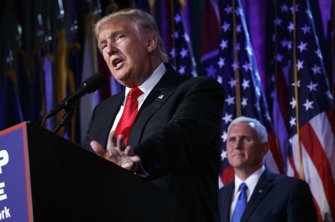 Vice president-elect Mike Pence, right, watches as President-elect Donald Trump speaks during an election night rally. (AP Photo/ Evan Vucci)
