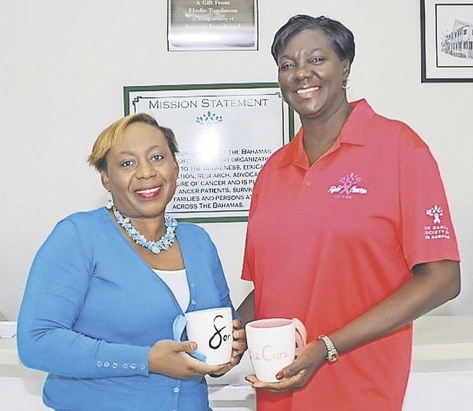 Entrepreneur Gina Smith (left) and Laverne Wildgoose of the Cancer Society of the Bahamas hold up the ‘Mugs for the Cure’.