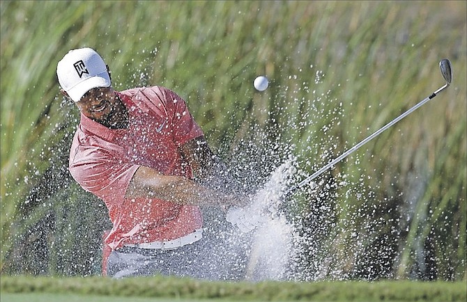 TIGER WOODS hits from a bunker onto the sixth green during the Pro-Am at the Hero World Challenge golf tournament yesterday at the Albany Resort in Nassau, Bahamas. 
(AP Photo/Lynne Sladky)