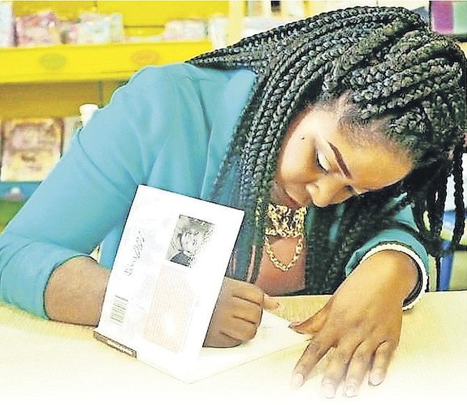 ShaKeisha McKenzie signs a copy of her book.