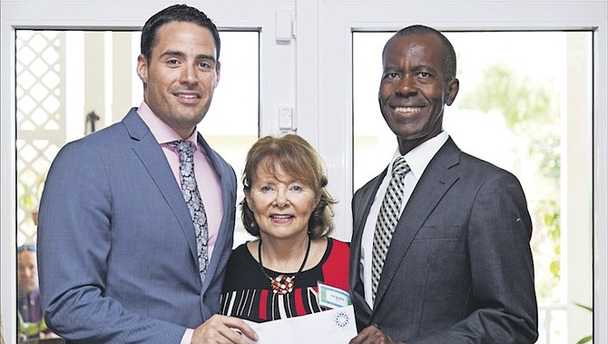 Sean Moree, Director (left), and Philip Smith, Executive Director, receive a donation to the Bahamas Feeding Network from Angela Moree, Chairwoman of the Women’s Corona Society of the Bahamas. 
Photo: Cay Focus Photography
