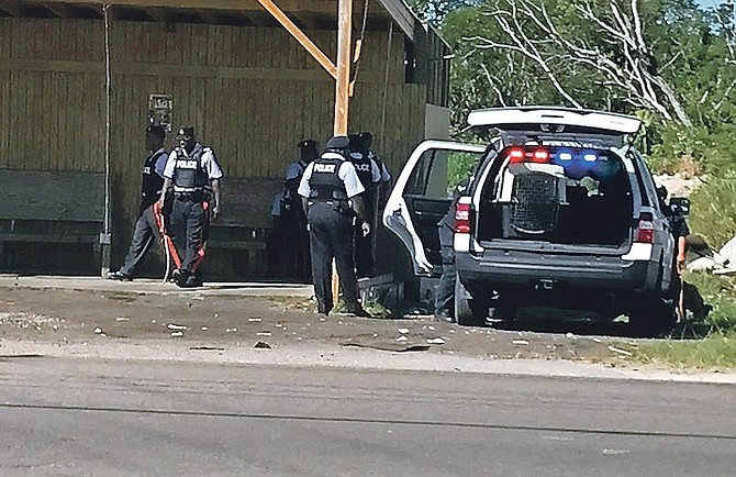 Police seach the carwash on Carmichael Road, where they arrested a man after finding a pistol on Thursday. Photo: Valden Fernander 

