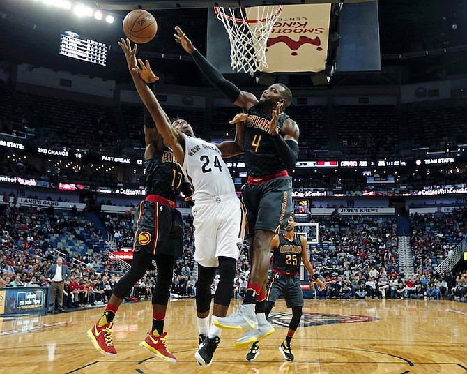 New Orleans Pelicans guard Buddy Hield (24) goes to the basket against Atlanta Hawks guard Dennis Schroder (17) and forward Paul Millsap (4) in the second half of an NBA basketball game in New Orleans, Thursday, Jan. 5, 2017. The Hawks won 99-94. (AP Photo/Gerald Herbert)
