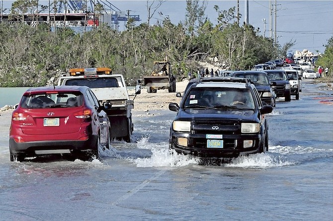 Cars splashing through the flood water on Fishing Hole Road. 