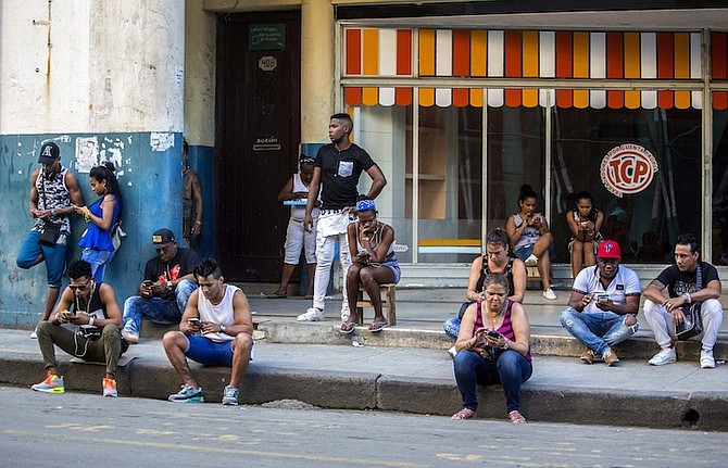 People use a public wifi hotspot in Havana, Cuba. Home internet came to Cuba in December 2016, in a limited pilot programme that’s part of the most dramatic change in daily life since the declaration of detente with the United States. (AP)