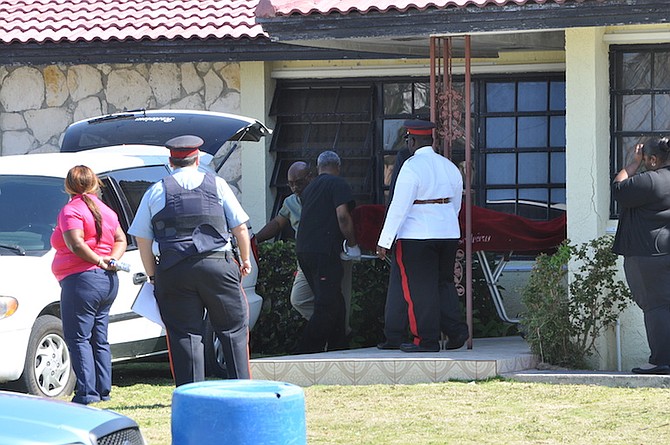 The body of a young man is taken away from a house in South Bahamia, Freeport, on Thursday morning. Photo: Vandyke Hepburn/BIS