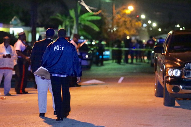 POLICE officers at the scene of Sunday night's fatal shooting in Yellow Elder Gardens. Photo: Terrel W Carey/Tribune Staff