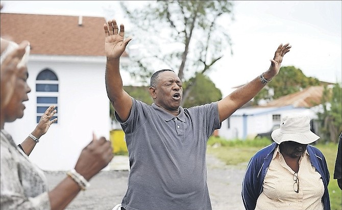 Senior Pastor at the Church of God of Prophecy Bishop Anthony Roker and his church members held a prayer drive along with Sam Williams, president of The Bahamas Love and Care Association, in the Grove. Photo: Shawn Hanna/Tribune Staff
